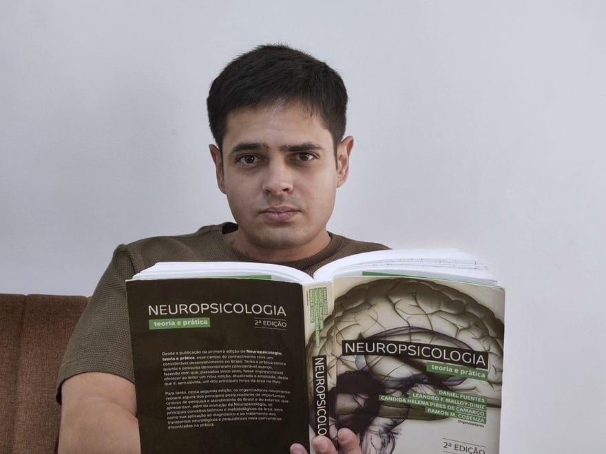 Felipe Rippel lendo o manual de neuropsicologia de Malloy-Diniz e Fuentes